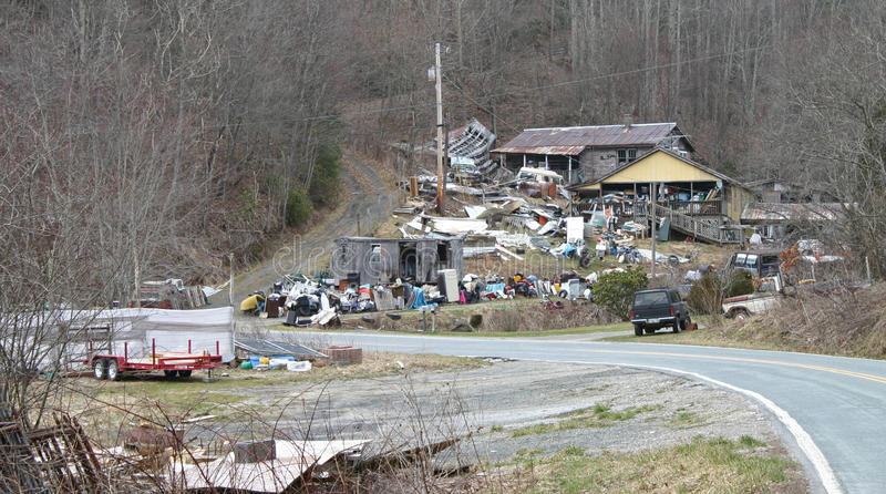 junky-yard-unsightly-trash-covers-hillside-roadway-front-neglected-house-51858776.jpg